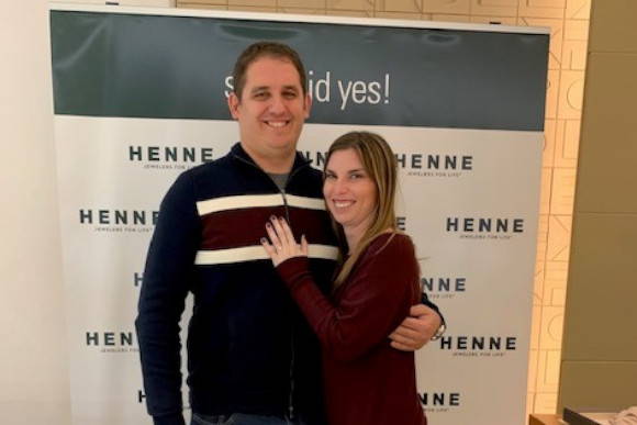 Henne Engagement Ring Couple Jeff & Chelsea Pose in Front of Henne's "She Said Yes!" Sign