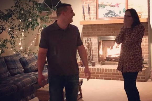 Brent Proposing to Faith by the Fireplace with an Engagement Ring from Henne Jewelers