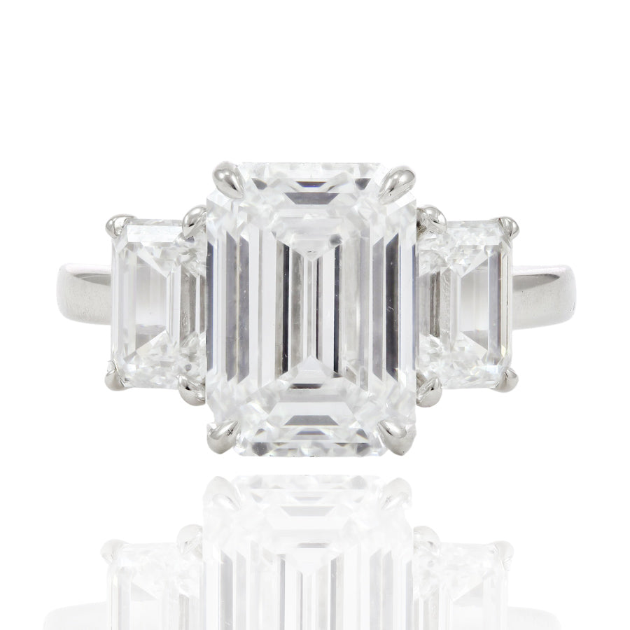 PLATINUM THREE-STONE RING WITH A 5.03CT CENTER EMERALD-CUT DIAMOND AND EMERALD SIDES 2.05CTW