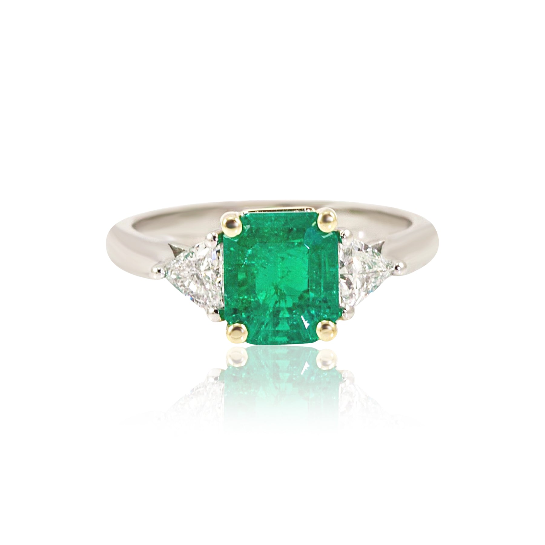 PLATINUM AND 18K YELLOW GOLD EMERALD AND TRILLIANT CUT DIAMOND THREE-STONE RING